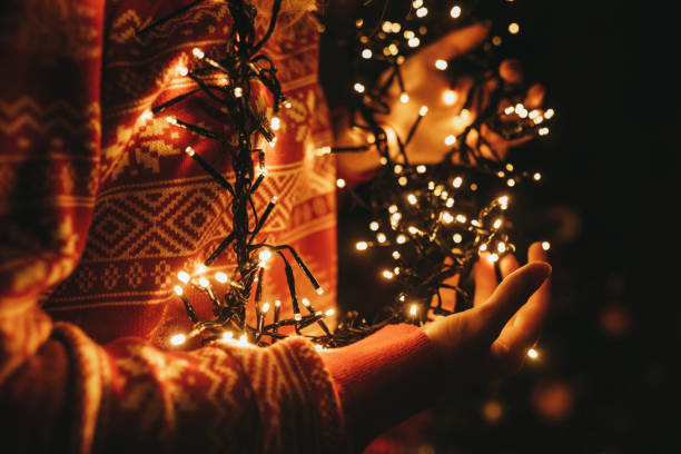 istock Young woman holding Christmas lights 1287961941