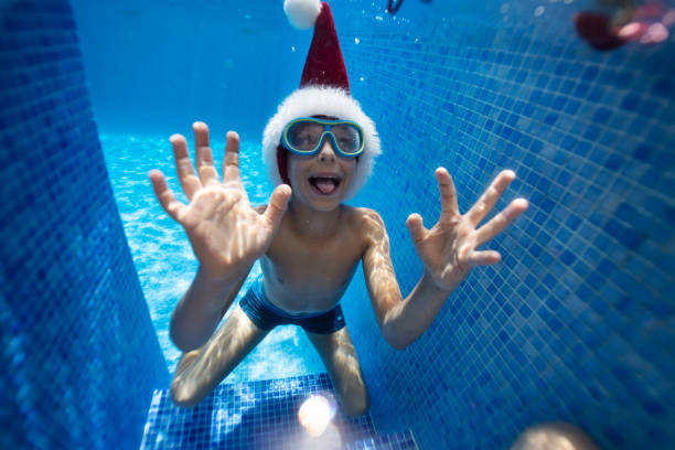 istock Little boy playing with baubles in pool on summer Christmas 1287964299