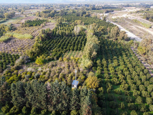 istock Flying with drone over the stream bed, tree fields, driveways, city and mountain views. 1287964754