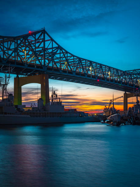 istock Sunset River Landscape with View of Bridge and Warships 1287968595