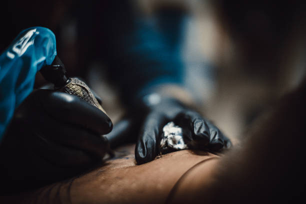 istock Close up of artist tattooing a customer in his studio 1287973449