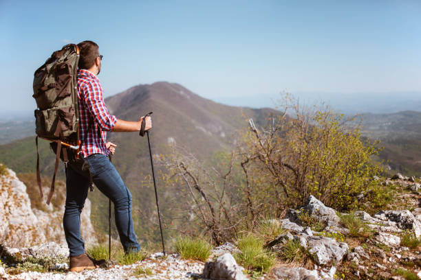 istock Man traveling with backpack hiking in mountains 1287974635