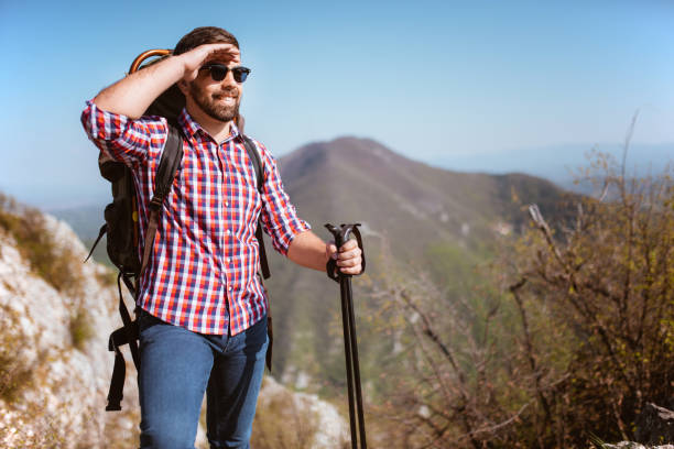istock Man traveling with backpack hiking in mountains 1287974832