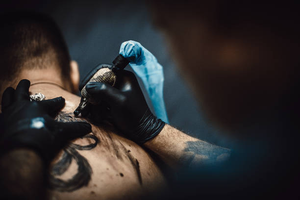 istock One artist tattooing a customer in studio 1287975379