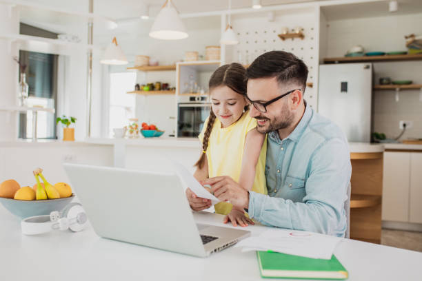 istock Father working from home with his daughter in his lap 1287976945