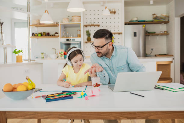 istock Father is working from home and his daughter is writing homework 1287977031