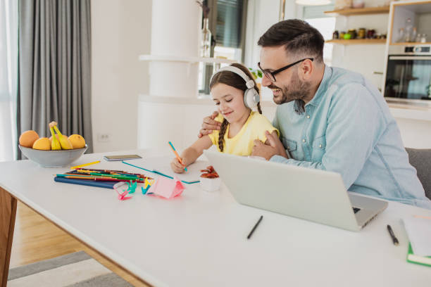 istock Father is working from home and his daughter is writing homework 1287977247