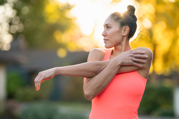 bella atleta femminile che si allunga prima dell'allenamento all'aperto - streatching foto e immagini stock