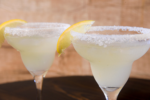 Frozen Margarita mixed drink with lime slice on plain background close up