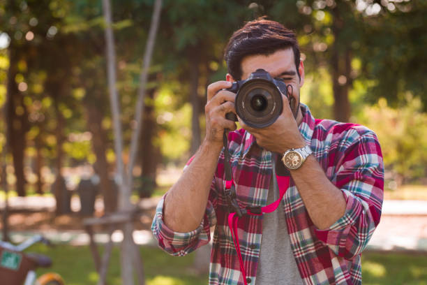 istock A handsome man raised the camera to take pictures. 1287993389