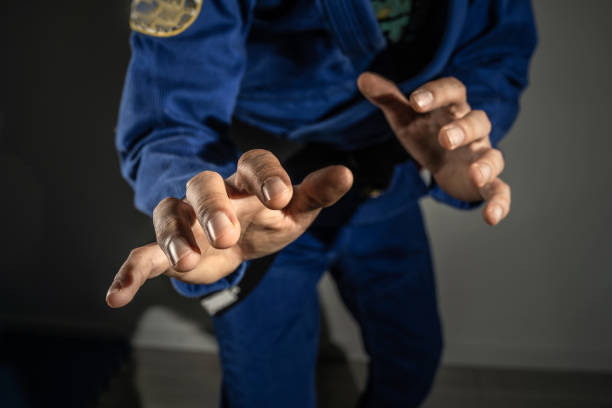 Close up on hands of unknown brazilian jiu jitsu bjj or judo grappler in fighting stance - front view midsection martial arts training concept Close up on hands of unknown brazilian jiu jitsu bjj or judo grappler in fighting stance - front view midsection martial arts training concept brazilian jiu jitsu photos stock pictures, royalty-free photos & images