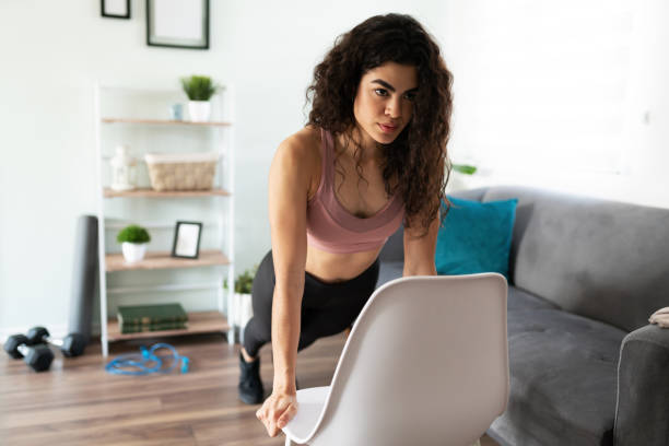 istock Active latin woman using a chair for her home workout 1288000658