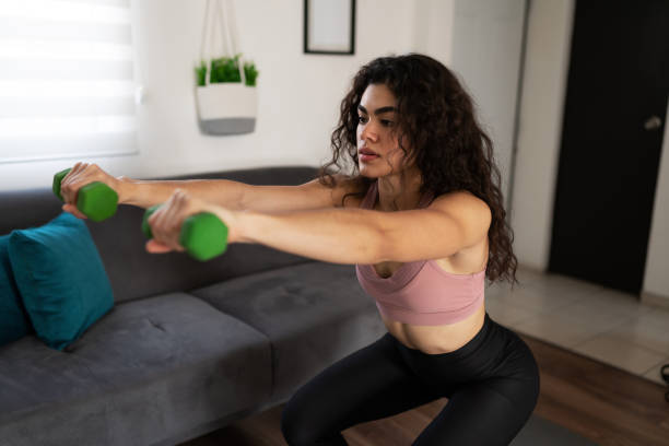 istock Sporty woman doing a cardio workout routine at home 1288000769
