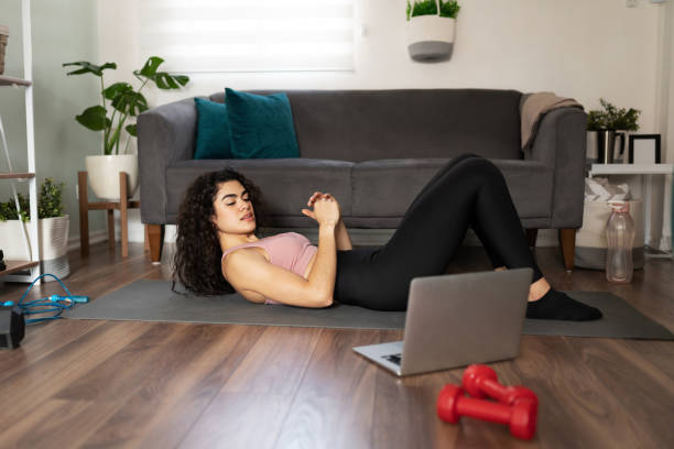 istock Latin woman exercising with sit ups at home 1288001171