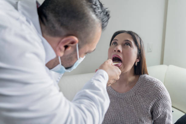 docteur faisant un examen médical sur la gorge d’une femme - doctor patient male tongue depressor photos et images de collection