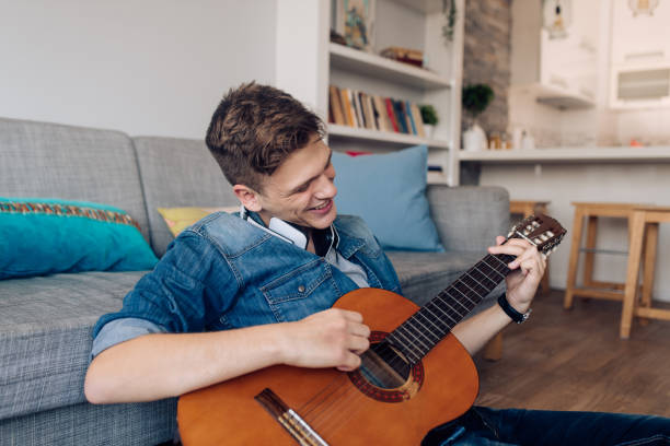 istock Boy playing a guitar and enjoying at home 1288005807