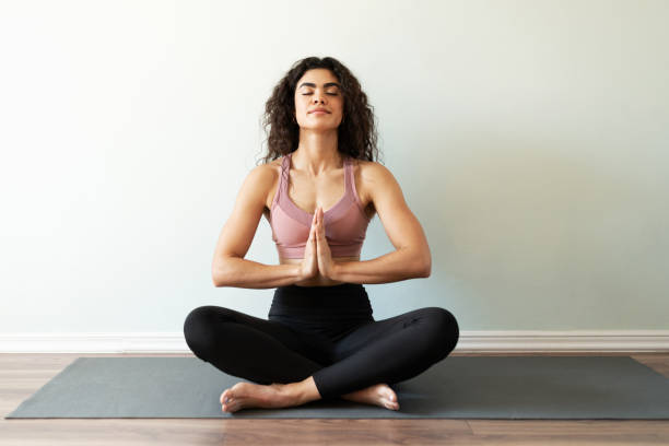 istock Latin woman meditating in a praying pose 1288005973