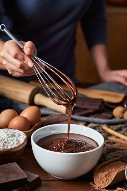 istock Woman hands making chocolate mousse and cookies on a wooden table in a rustic kitchen 1288010176