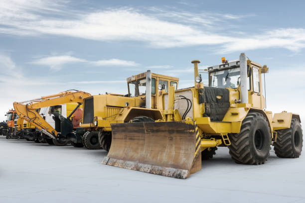 istock Two heavy wheeled tractor one excavator and other construction machinery isolated on bright 1288021270