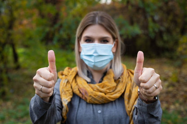 istock Woman with mask showing thumbs up 1288022825