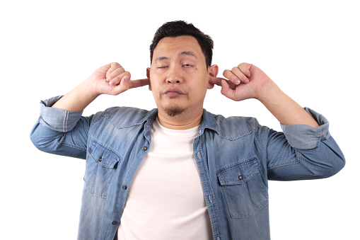 Young Asian man closing his ears dont want or avoiding to hear bad news, stress under mental pressure concept