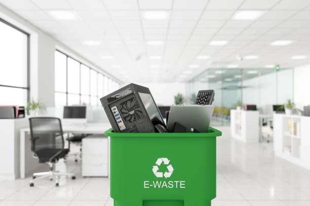 déchets électroniques recueillis dans la poubelle de couleur verte avec le symbole e-déchets sur elle dans le bureau - electronics photos et images de collection