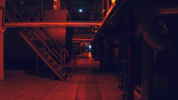 istock Long corridor at the factory in red light at night 1288027565