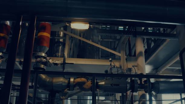 istock Large pipes in a factory close up at night 1288027567