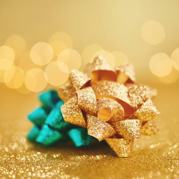istock Christmas gift bows on glittery gold background 1288027764