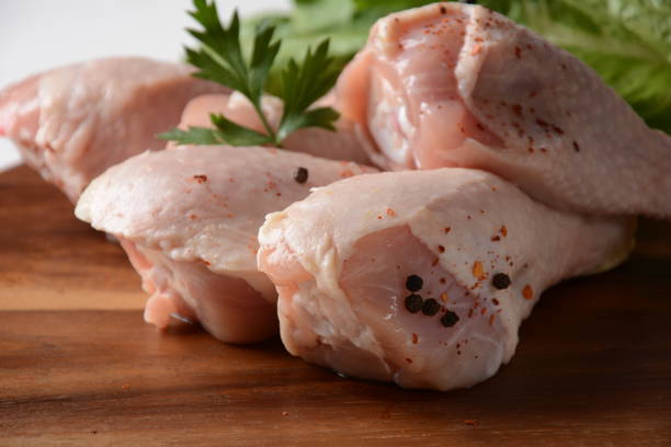 istock Raw chicken legs with spices on wooden board 1288033778