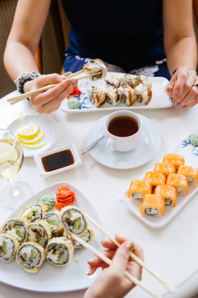 istock Two women eating japanese sushi rolls 1288038016