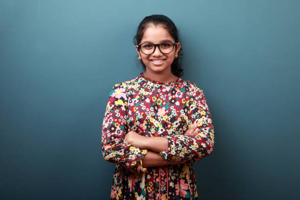 istock Happy young girl standing against a blue wall background 1288039241