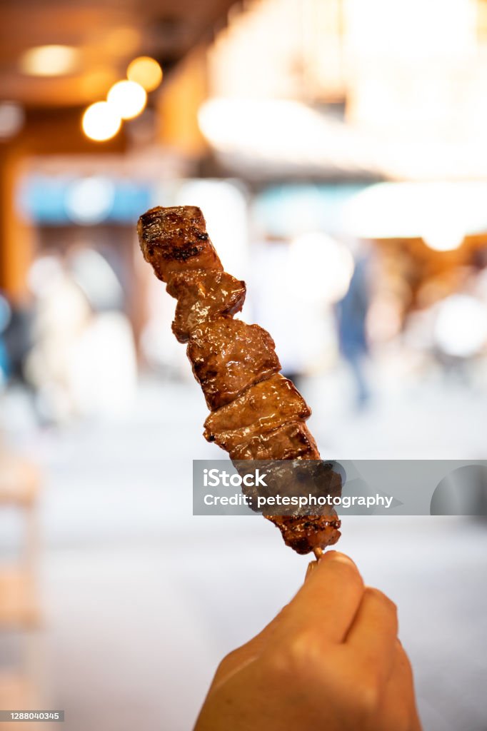 Japanese street food - Famous Matsusaka beef on a stick Street food in Ise, Mie prefecture features the famous Matsusaka beef on a stick and although rather expensive are very popular with visitors. Matsusaka beef is the meat of Japanese Black cattle reared under strict conditions in the Matsusaka region of Mie in Japan Eating Stock Photo