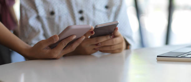 istock Hands holding two smartphone to consulting on their work in office room 1288041236