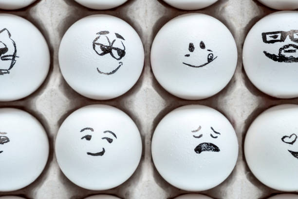 istock White eggs in cardboard box with different faces painted on them. Eggs with emotions. 1288041252