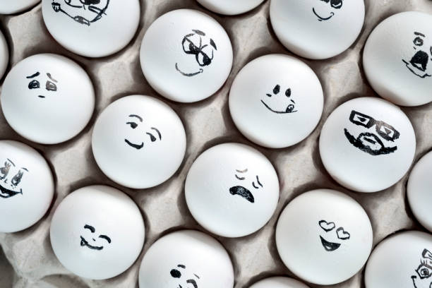 istock White eggs in cardboard box with different faces painted on them. Eggs with emotions. 1288041268