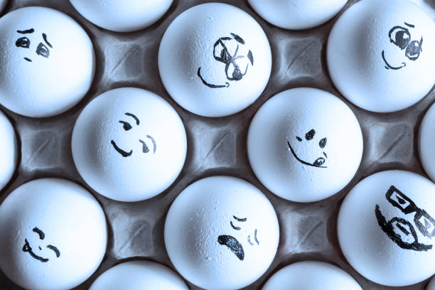 istock White eggs in cardboard box with different faces painted on them. Eggs with emotions. 1288041271