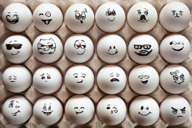 istock White eggs in cardboard box with different faces painted on them. Eggs with emotions. 1288041277