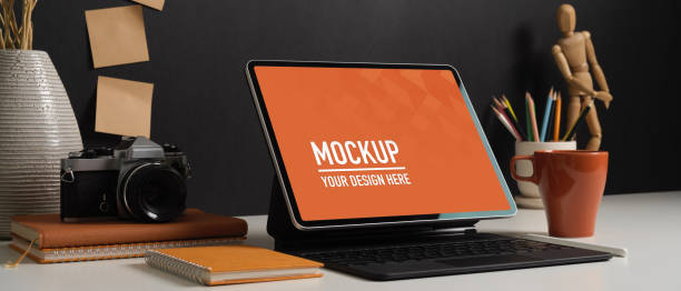 istock Worktable with tablet, keyboard, camera, stationery and decorations in home office room 1288041544