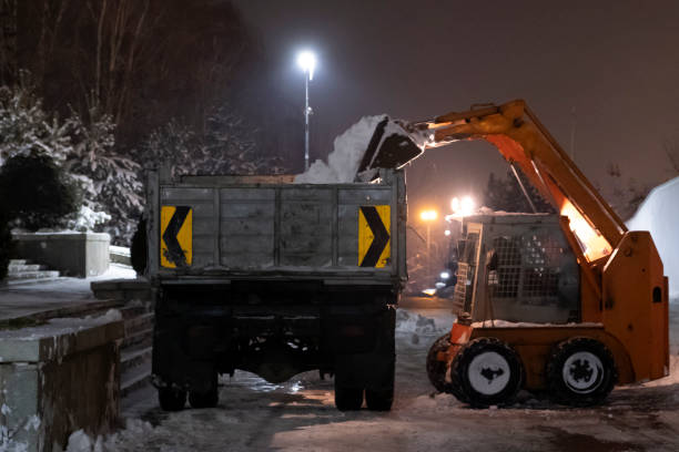 istock Small wheel loader is unloading snow into a dump truck. Cleaning snow after storm. 1288044257