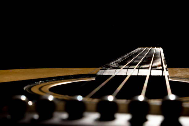 istock Acoustic guitar on black background. 1288044275
