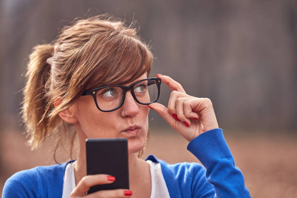istock Young woman using smartphone in autumn colored park. 1288044714
