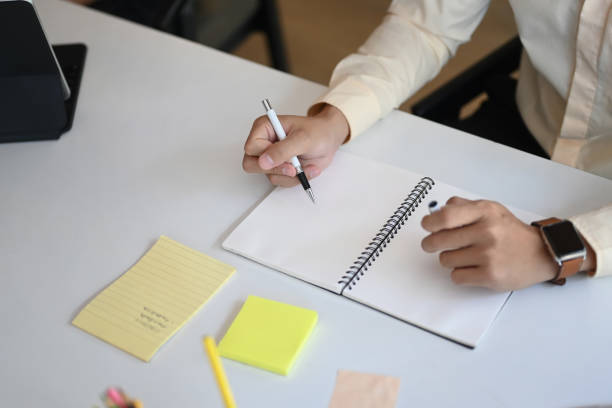 istock Cropped shot of businessman holding a pen taking note on notebook. 1288048127