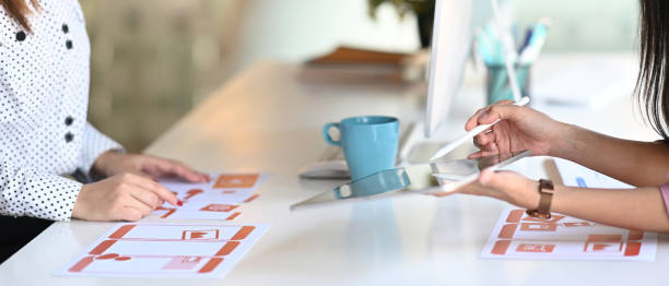 istock Cropped shot of group of web designers are working together to develop a mobile responsive website in office. 1288048983