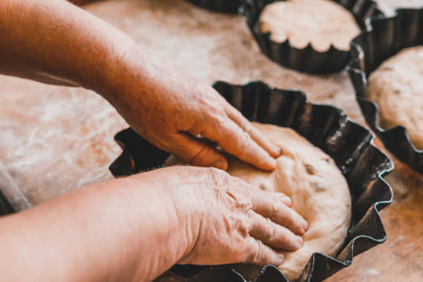 istock Woman kneads and shapes fresh bread into molds. 1288049509