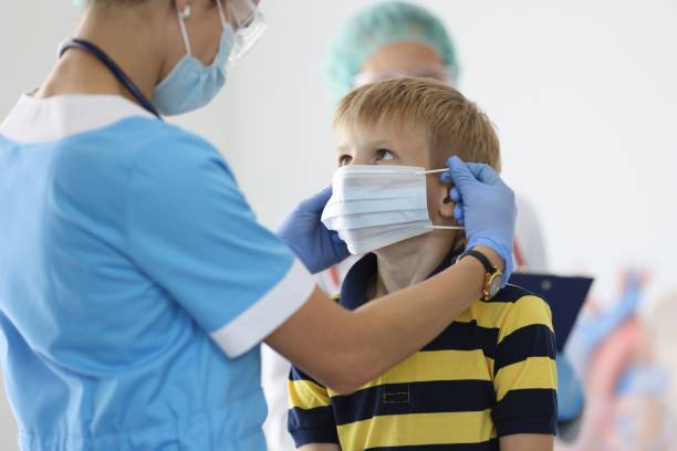 istock Boy is put on protective medical mask in doctor's office. 1288050573