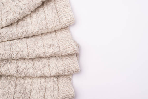 istock Top flatlay close up view photo of folded knitted textile lying on white background with blank empty space 1288051904