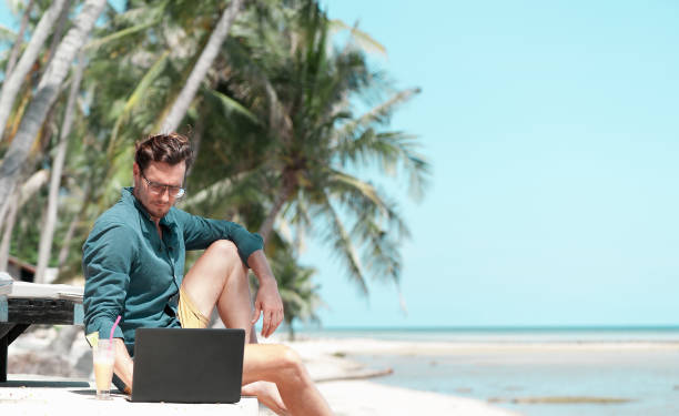 istock Man freelancer working with laptop at the beach 1288052692
