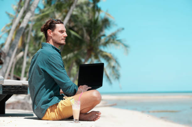 istock Man freelancer working with laptop at the beach 1288052699