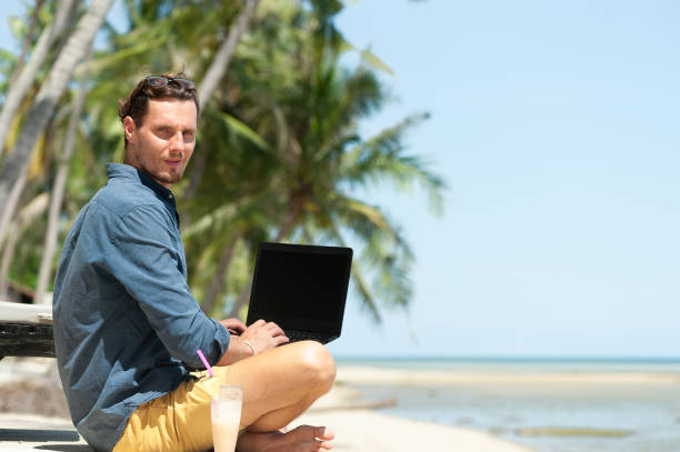 istock Man freelancer working with laptop at the beach 1288052722